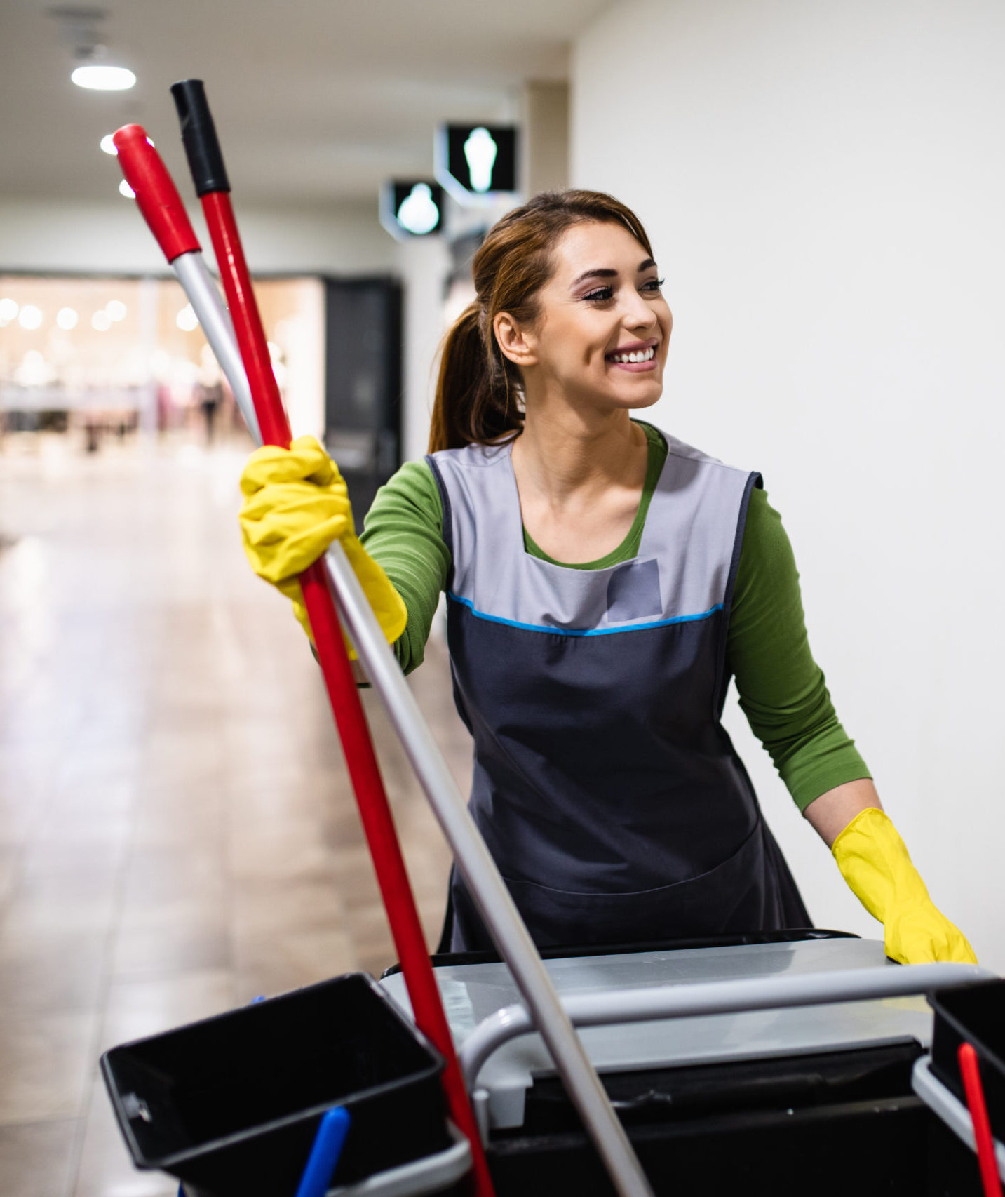 Beautiful young woman cleaning at shopping mall. Cleaning concept.